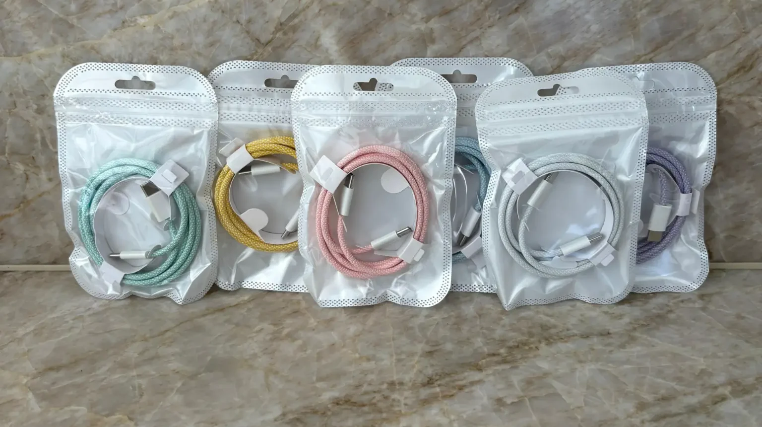 All six pastel 1m braided USB-C to USB-C cables in real ChargeUp Co. packaging: light blue, light pink, light green, white, light yellow and light purple